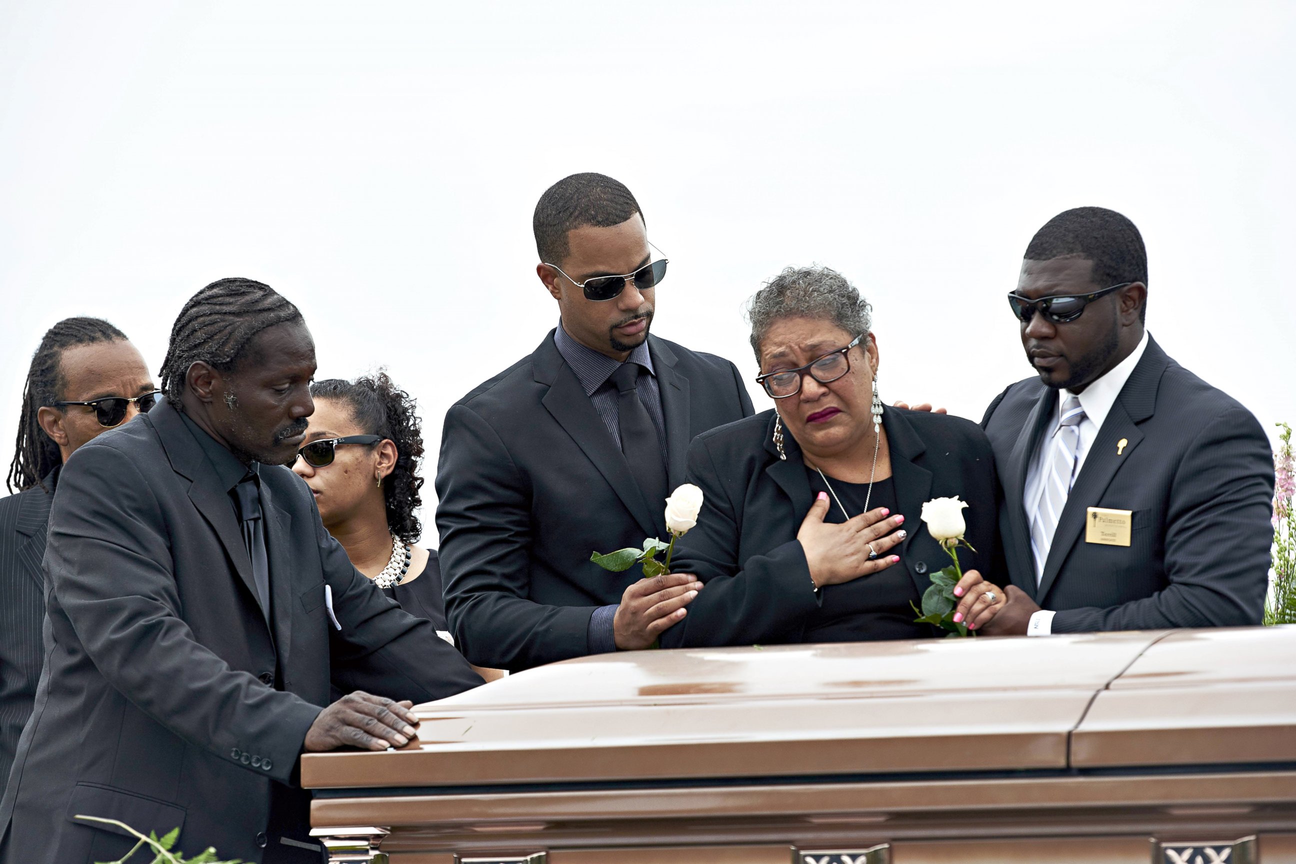 PHOTO: Sharon Risher, 2nd from right, and Gary Washington, left, pay their respects at the casket of their mother, Ethel Lance, 70, before her burial at the AME Church cemetery, June 25, 2015, in North Charleston, S.C.