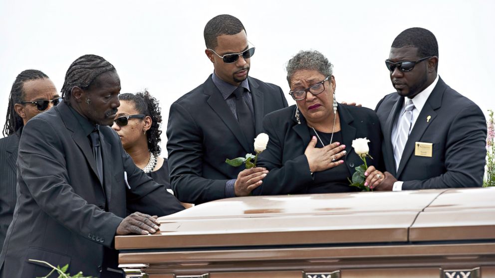 PHOTO: Sharon Risher, 2nd from right, and Gary Washington, left, pay their respects at the casket of their mother, Ethel Lance, 70, before her burial at the AME Church cemetery, June 25, 2015, in North Charleston, South Carolina. 