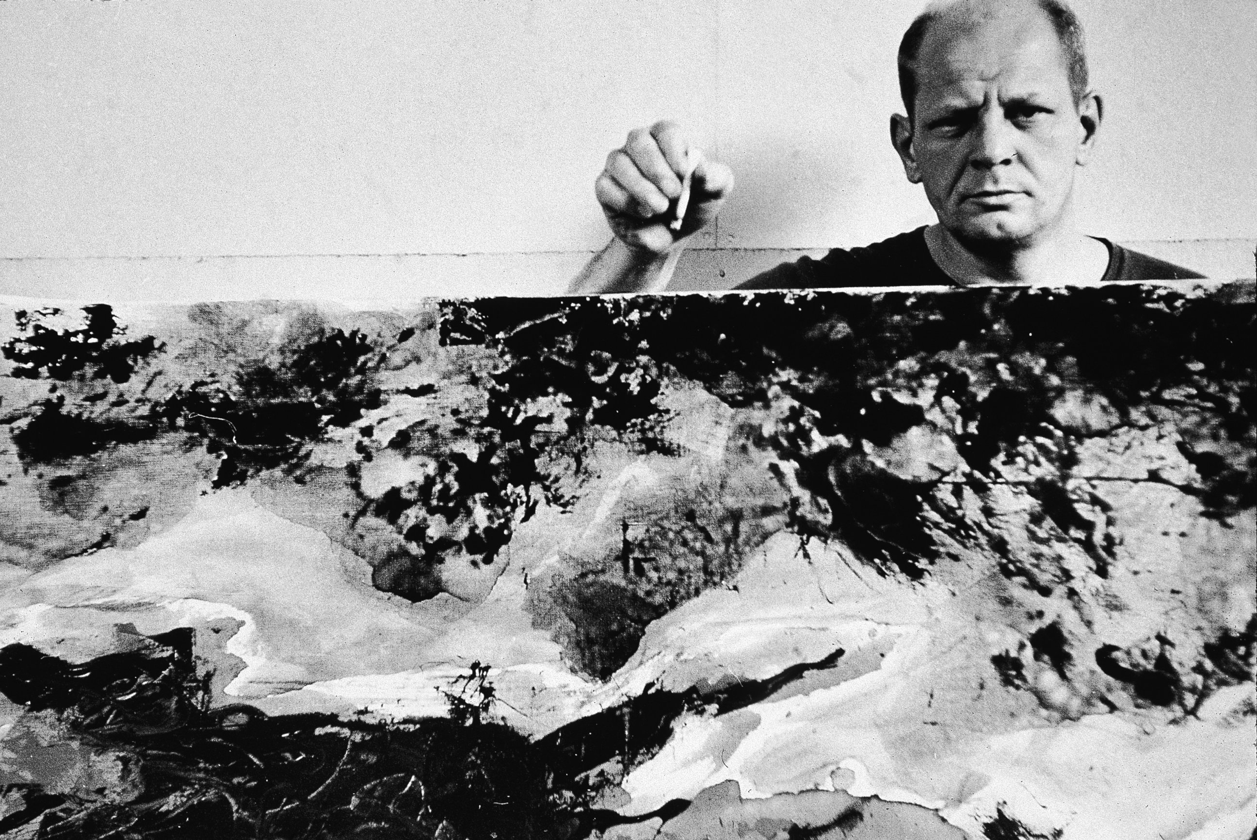 PHOTO: American abstract expressionist painter Jackson Pollock holds a cigarette with one of his paintings in his studio at 'The Springs,' East Hampton, N.Y., Aug. 23, 1953.