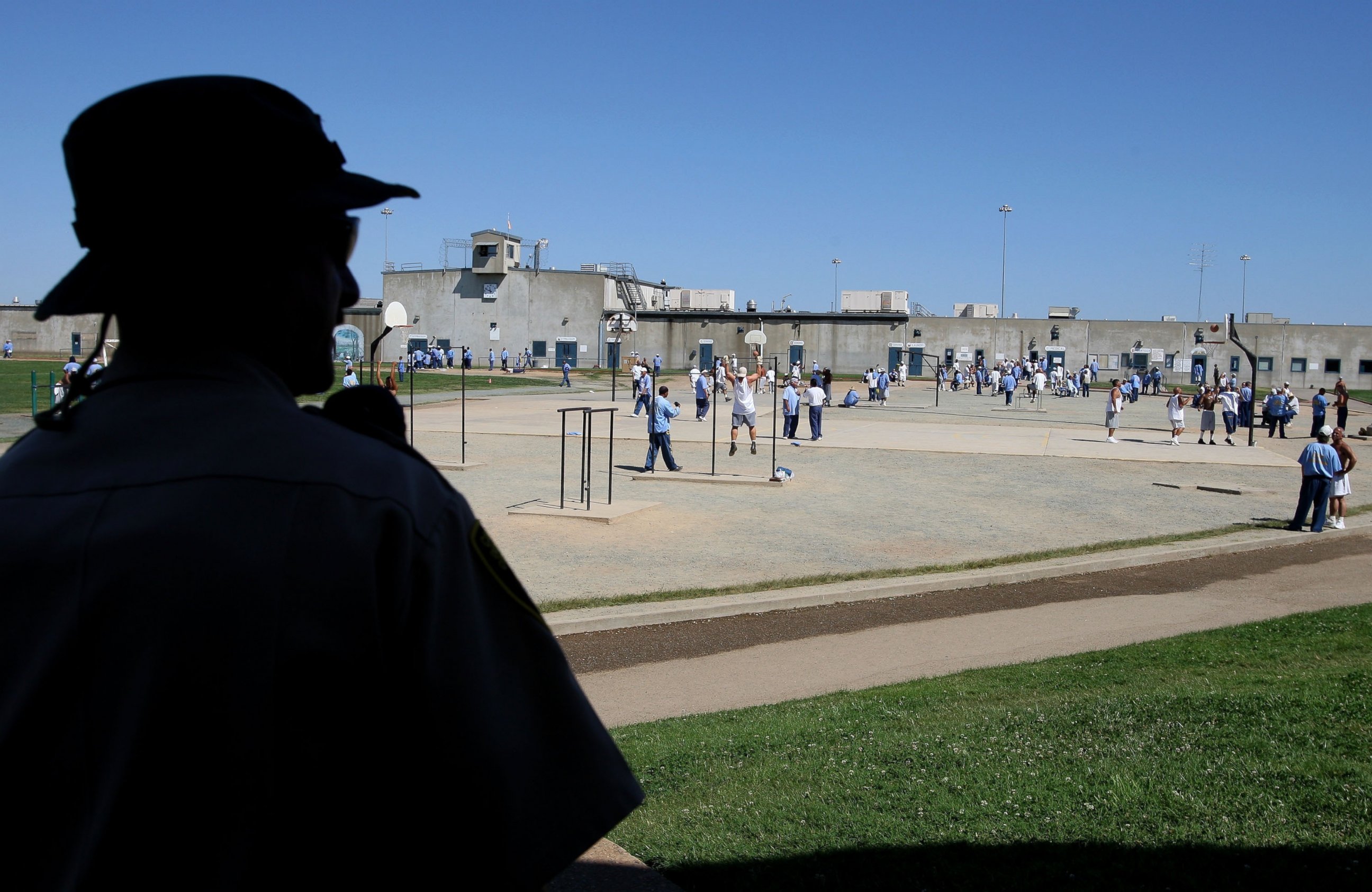PHOTO: A California Department of Corrections officer looks on as inmates at the Mule Creek State Prison exercise in the yard August 28, 2007 in Ione, California