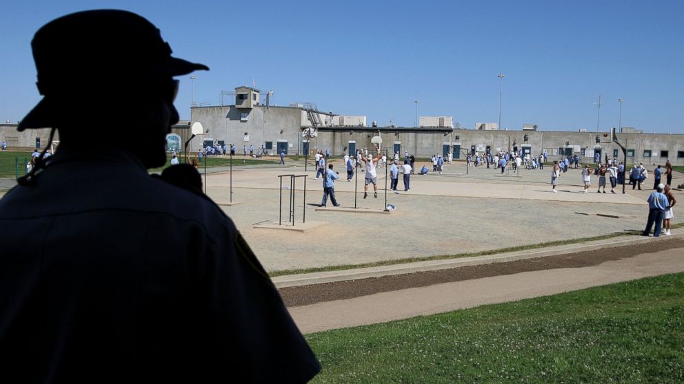 PHOTO: A California Department of Corrections officer looks on as inmates at the Mule Creek State Prison exercise in the yard August 28, 2007 in Ione, California