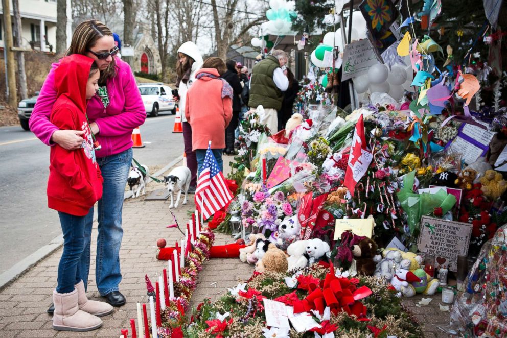 PHOTO: Deborah Gibelli holds her daughter, Alexandra Gibelli, age 9, while looking at a memorial for those killed in the school shooting at Sandy Hook Elementary School, on Dec. 24, 2012 in Newtown, Conn.