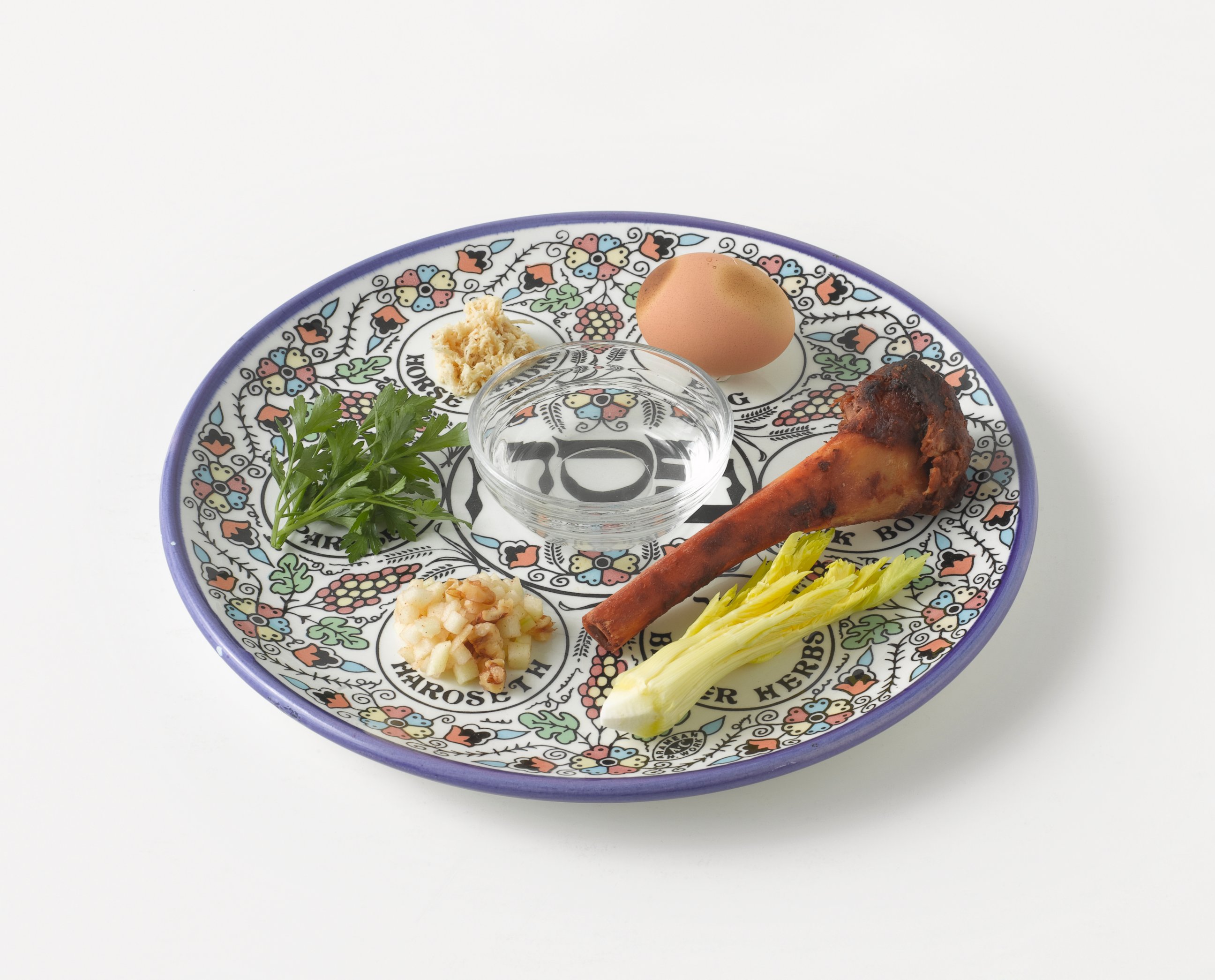 PHOTO: A Passover Seder of roasted egg, roasted bone, parsley, charoset, celery, nuts and salt water on a plate.