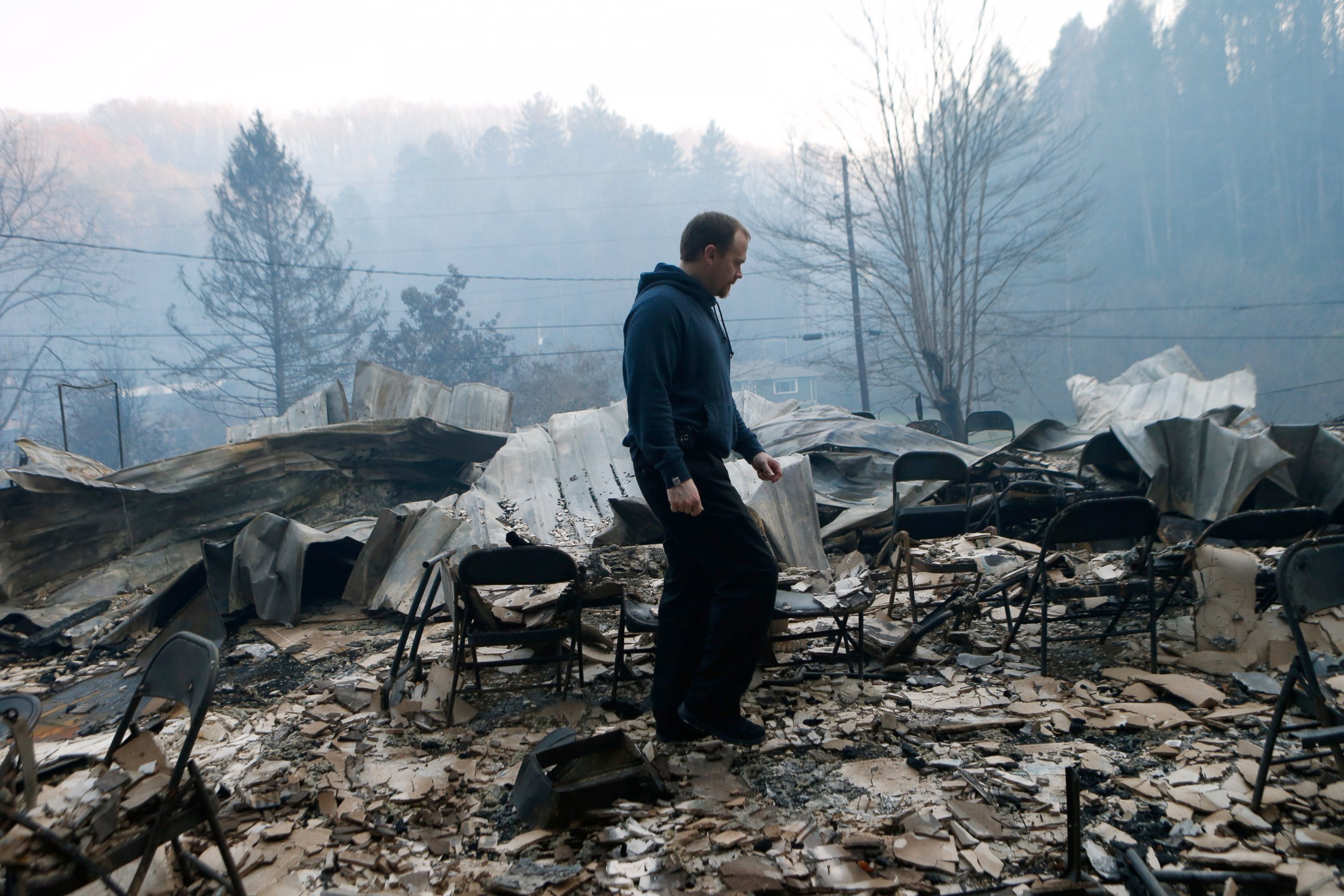 PHOTO: Trevor Cates, walks through the smoldering remains of the fellowship hall of his church, the Banner Missionary Baptist Church as he inspects damage after the wildfires, Nov. 29, 2016, in Gatlinburg, Tennessee. 