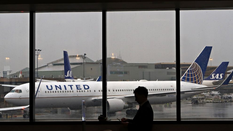 PHOTO: A man uses his mobile phone in front of a United Airlines plane at Newark Liberty Airport, April 6, 2017, in Newark, NJ. 