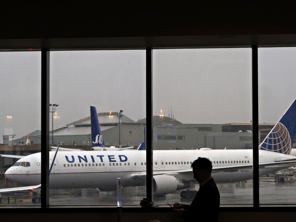 PHOTO: A man uses his mobile phone in front of a United Airlines plane at Newark Liberty Airport, April 6, 2017, in Newark, NJ.