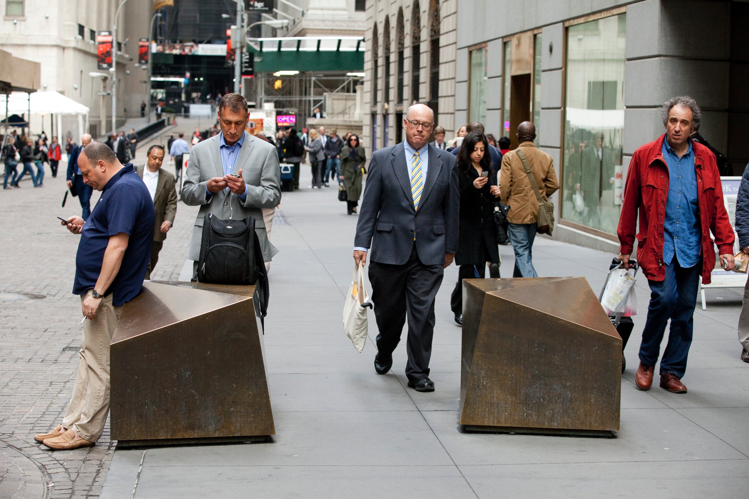 PHOTO: Commuters walk to work down Wall Street past artistic security barricades near the NYSE, April 11, 2013 in New York.