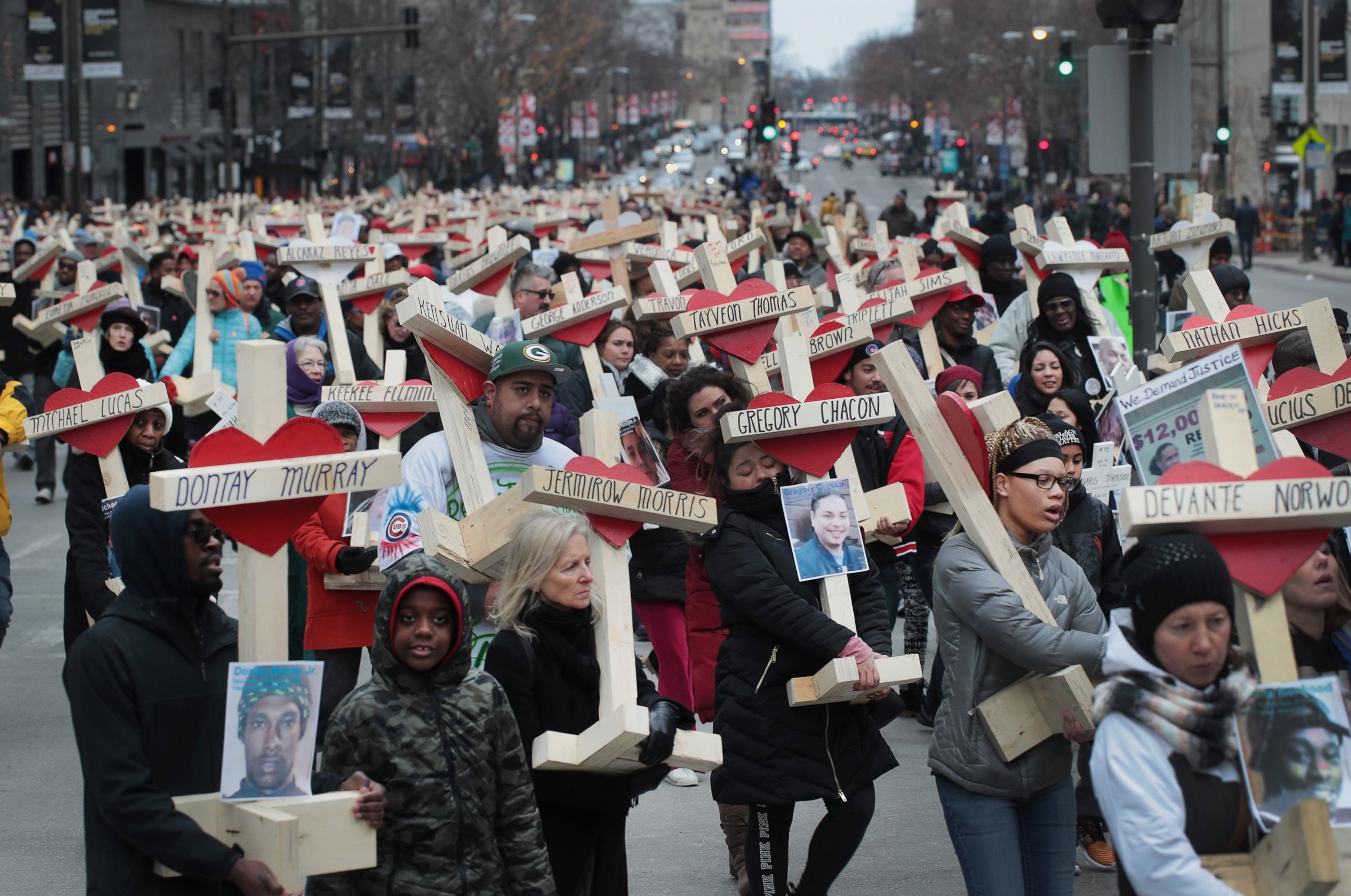 PHOTO: Residents, activists, and friends and family members of victims of gun violence march down Michigan Avenue carrying nearly 800 wooden crosses bearing the names of people murdered in the city in 2016, Dec. 31, 2016 in Chicago.
