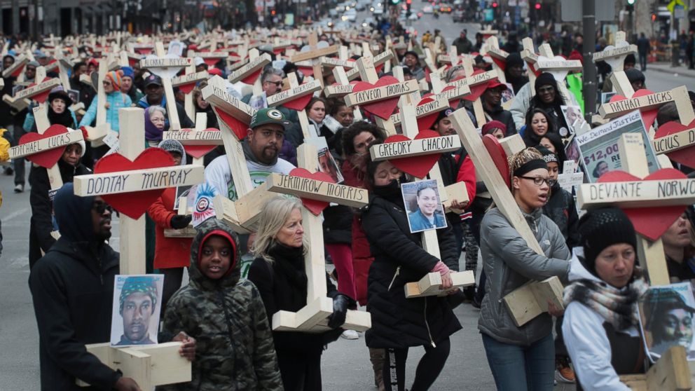 PHOTO: Residents, activists, and friends and family members of victims of gun violence march down Michigan Avenue carrying nearly 800 wooden crosses bearing the names of people murdered in the city in 2016, Dec. 31, 2016 in Chicago.
