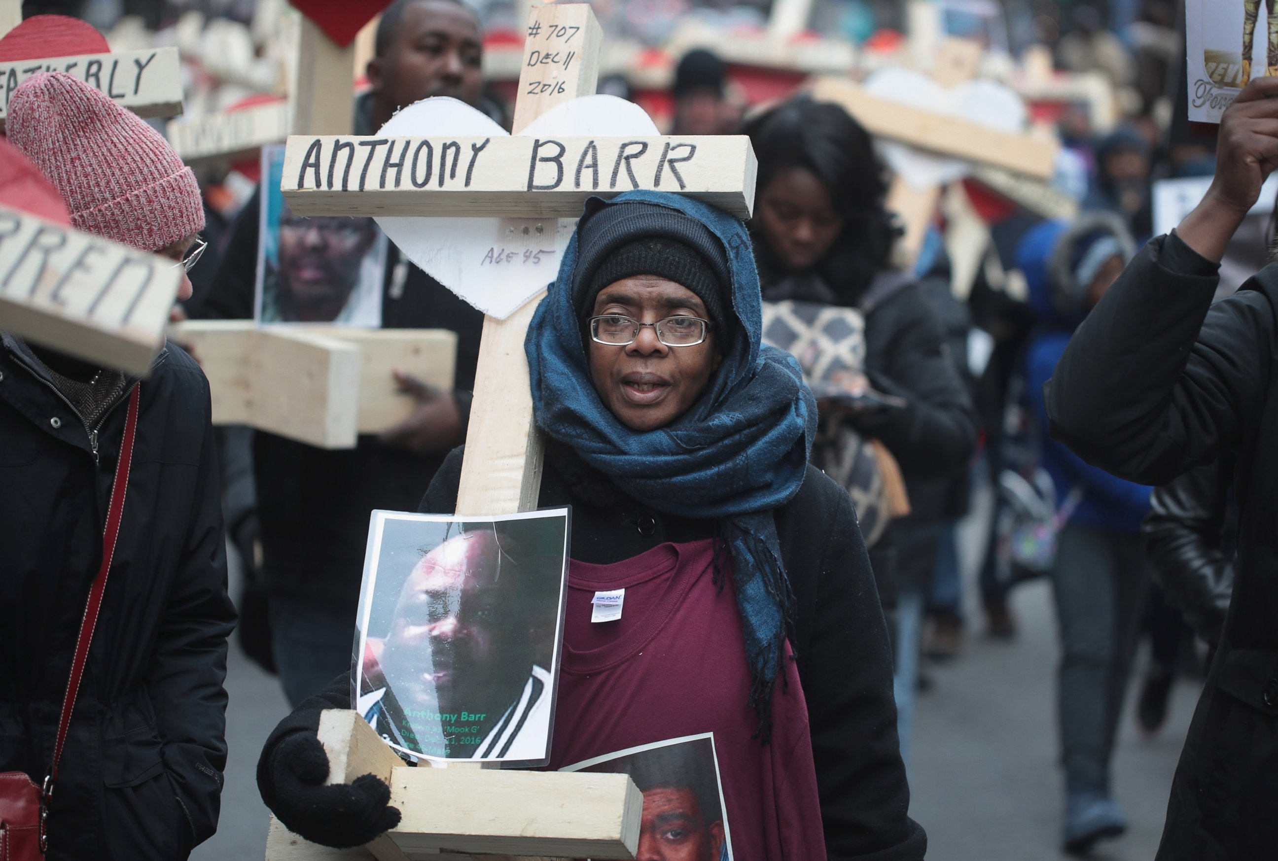 PHOTO: Melva Pratt carries a cross as she marches with other residents, activists, and family members of victims of gun violence down Michigan Avenue, Dec. 31, 2016 in Chicago.