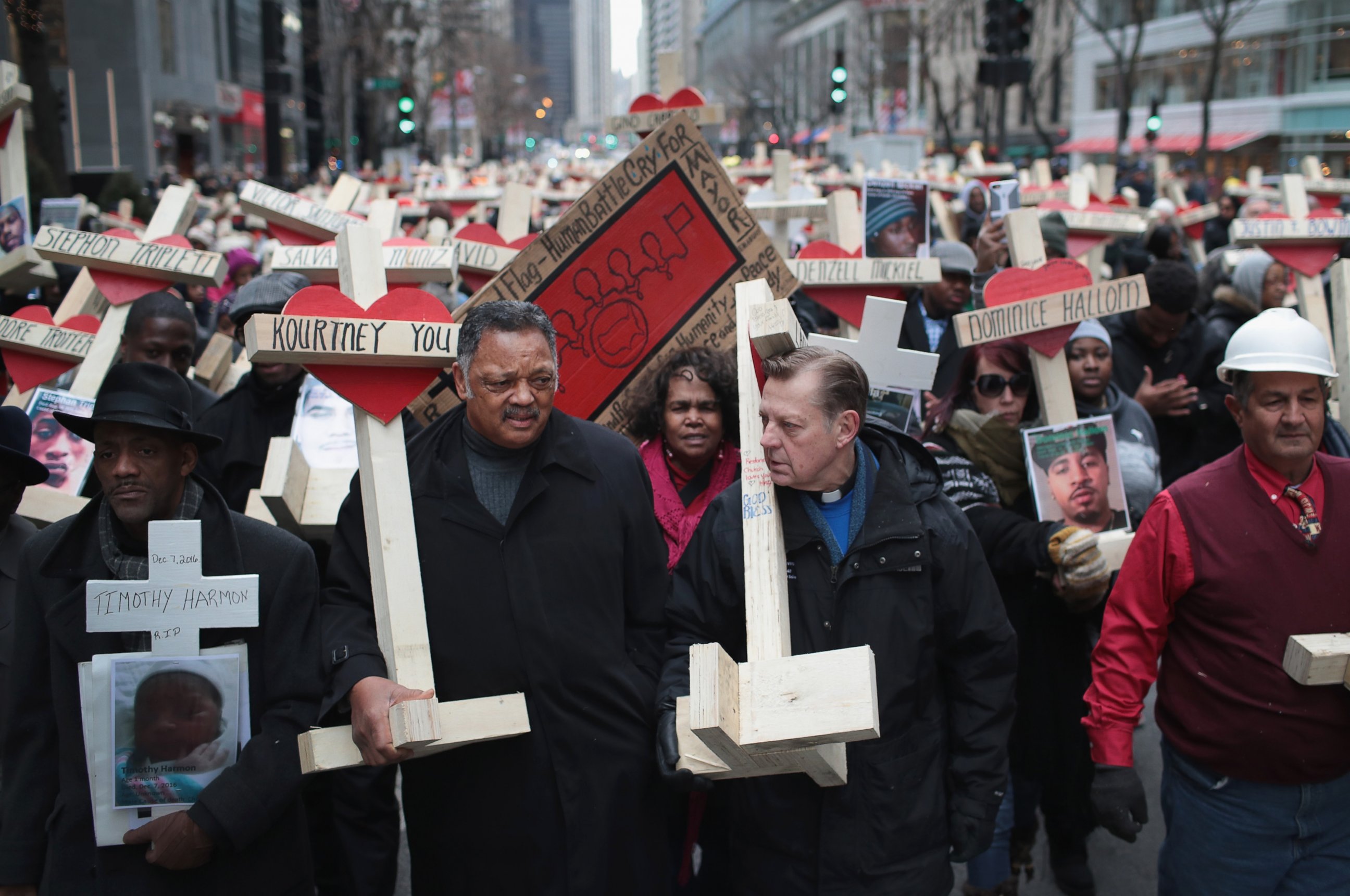 PHOTO: The Rev. Jesse Jackson (L) and Rev. Michael Pfleger carry crosses as they march with other residents, activists, and family members of victims of gun violence down Michigan Avenue, Dec. 31, 2016 in Chicago.
