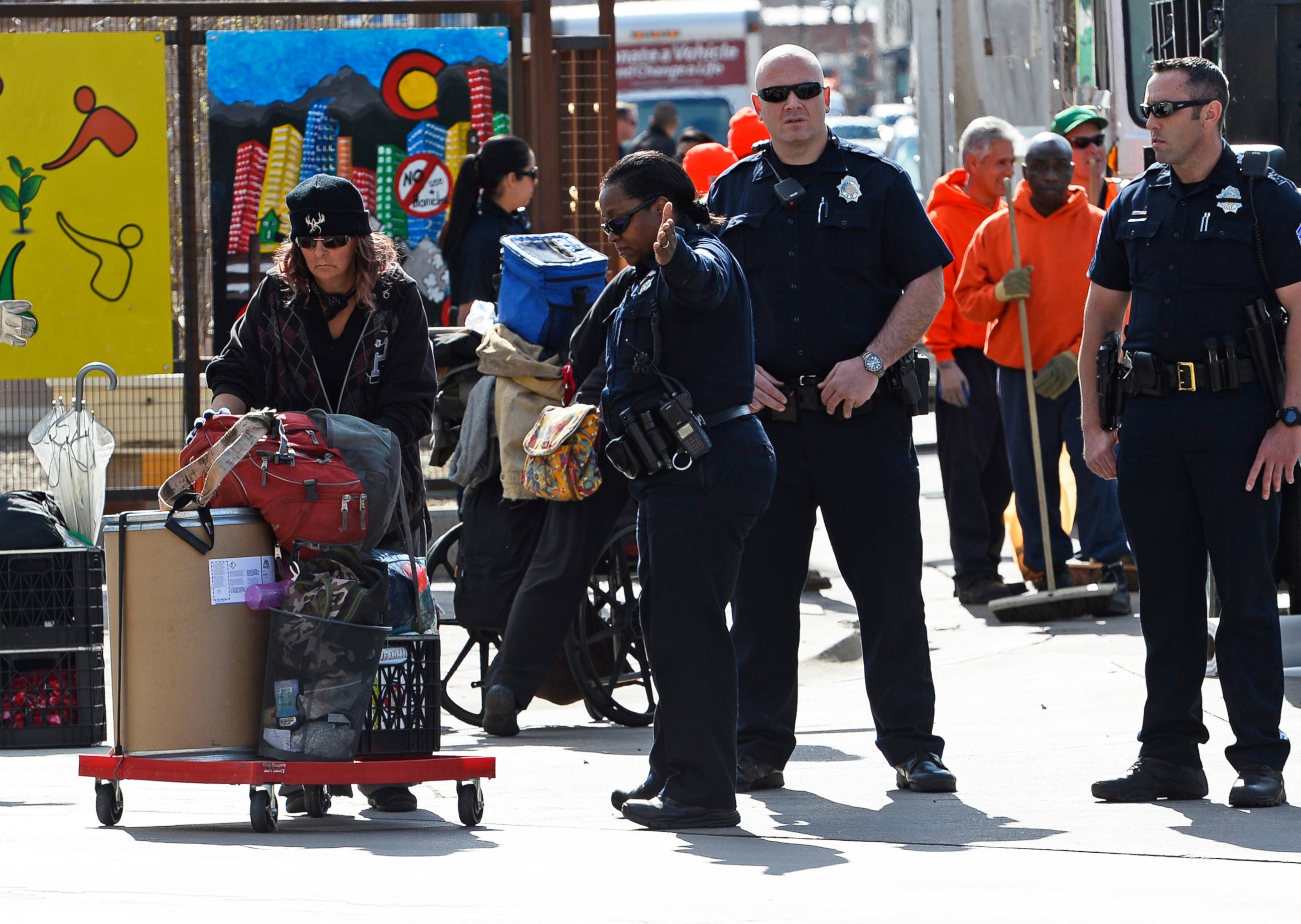 PHOTO: Homeless people remove their belongings as Denver Police and Sheriff deputies oversee their progress and enforce the law at the intersections of Broadway and Park Ave West in Denver, Colorado, March 8, 2016 in Denver, Colorado. 