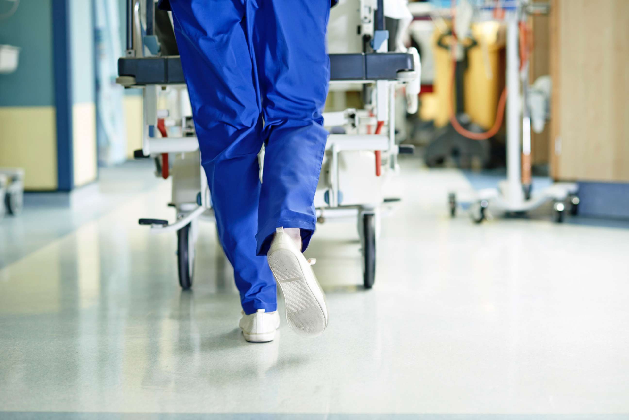 PHOTO: A medic runs with a gurney along a hospital corridor.