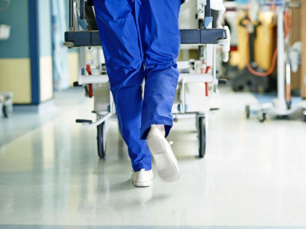 PHOTO: A medic runs with a gurney along a hospital corridor.