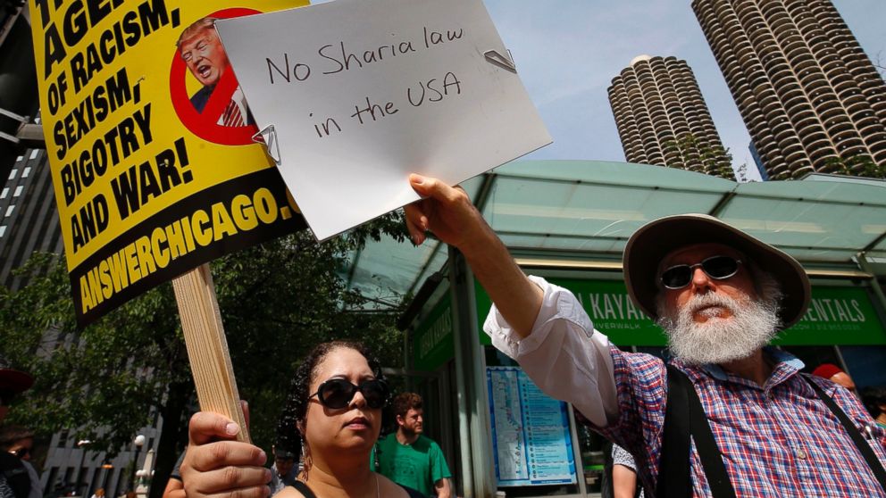 PHOTO: A pro-Muslim supporter (L) and a demonstrator with the "March Against Sharia" protest try to block out each others signs during a protest in Chicago, June 10, 2017. 