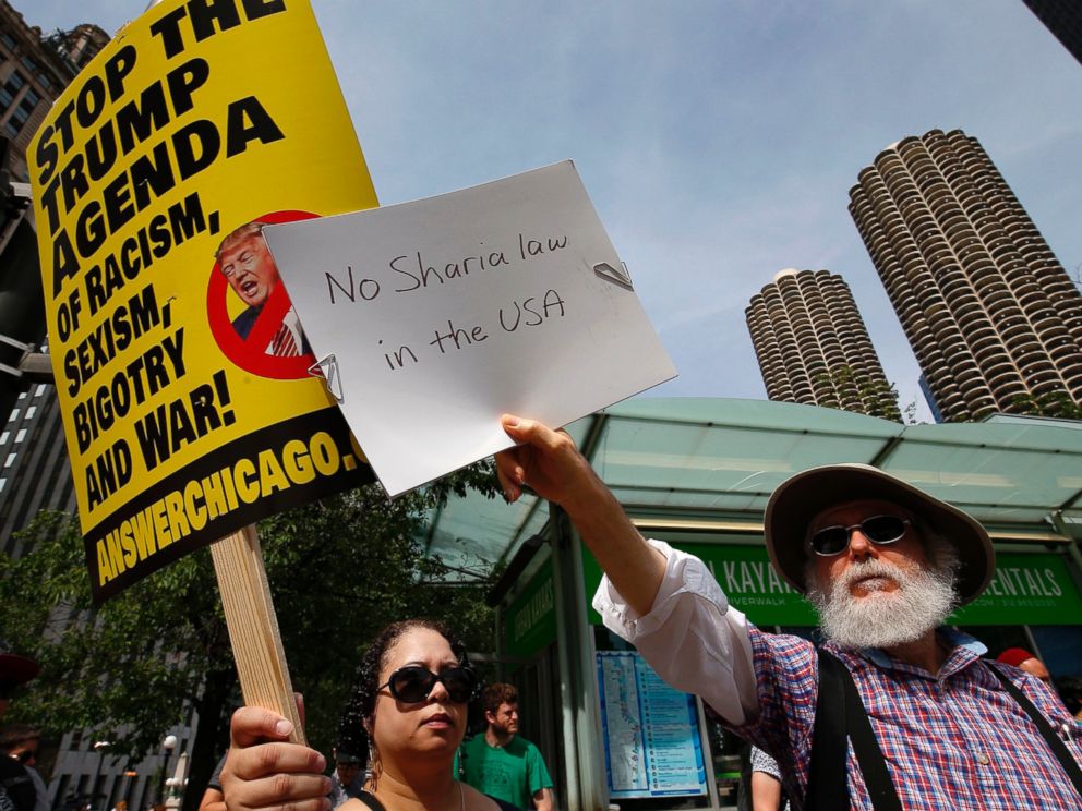 PHOTO: A pro-Muslim supporter (L) and a demonstrator with the "March Against Sharia" protest try to block out each others signs during a protest in Chicago, June 10, 2017. 