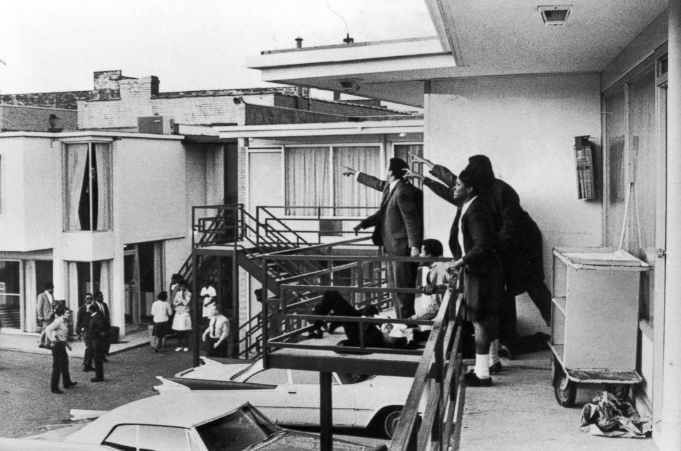 PHOTO: Civil rights leader Andrew Young, left, and others stand on the balcony of the Lorraine motel pointing in the direction of the shooter after the assassination of civil rights leader Dr. Martin Luther King, Jr., who is lying at their feet.  