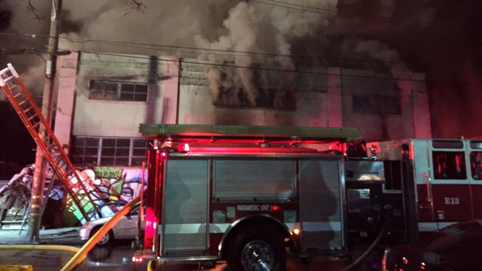 Smoke pours from a warehouse, which caught fire during a dance party in Oakland, California, Dec. 3, 2016.