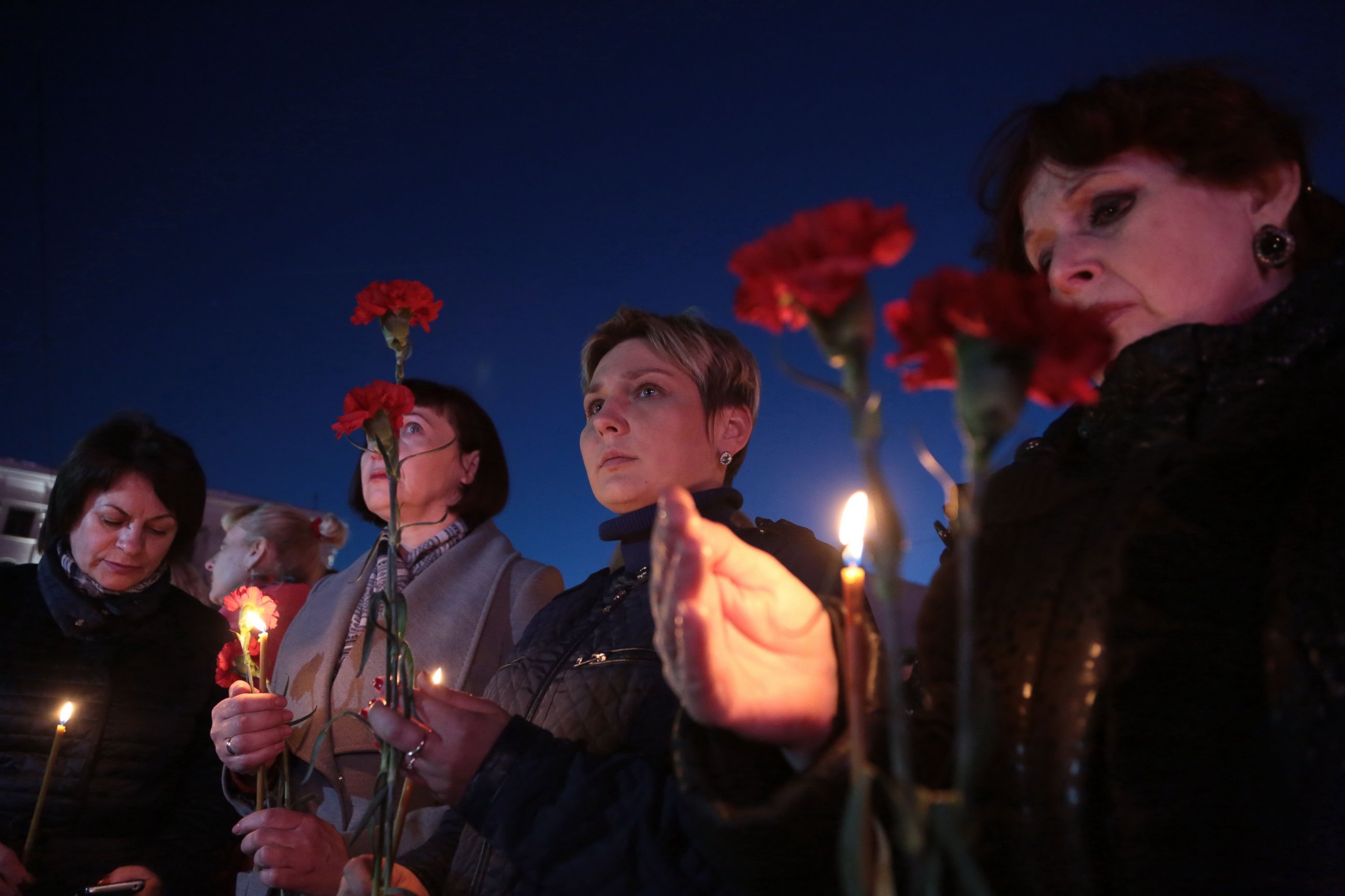 PHOTO: Women hold flowers and candles as they take part in a vigil in honor of the victims of the blast in the Saint Petersburg metro in Simferopol, Crimea, on April 3, 2017.