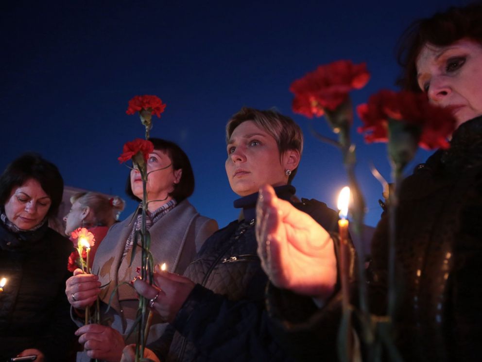 PHOTO: Women hold flowers and candles as they take part in a vigil in honor of the victims of the blast in the Saint Petersburg metro in Simferopol, Crimea, on April 3, 2017.