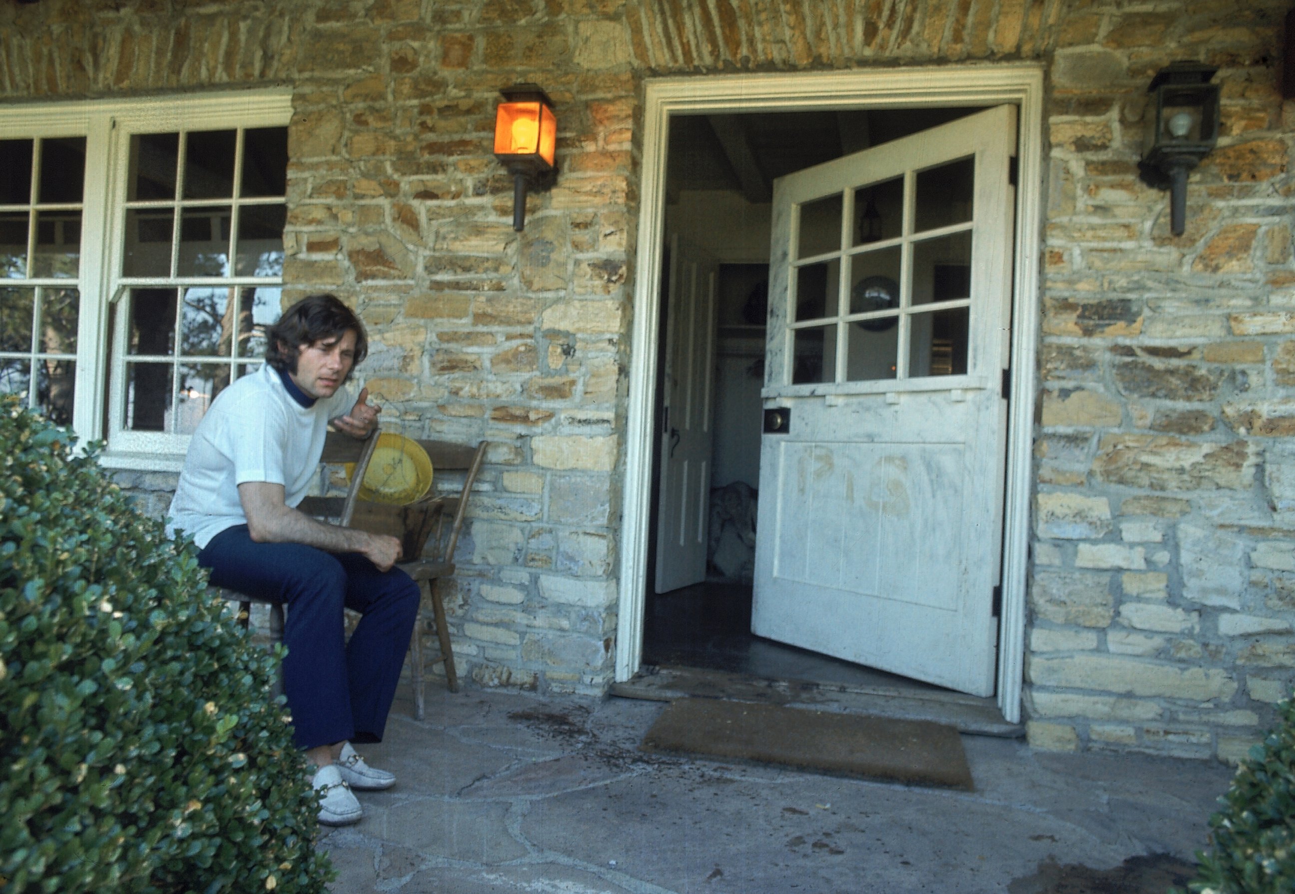 PHOTO: Director Roman Polanski sitting outside his home after the murder of his wife Sharon Tate, Aug. 1, 1969. The word "PIG" was scrawled on door. 