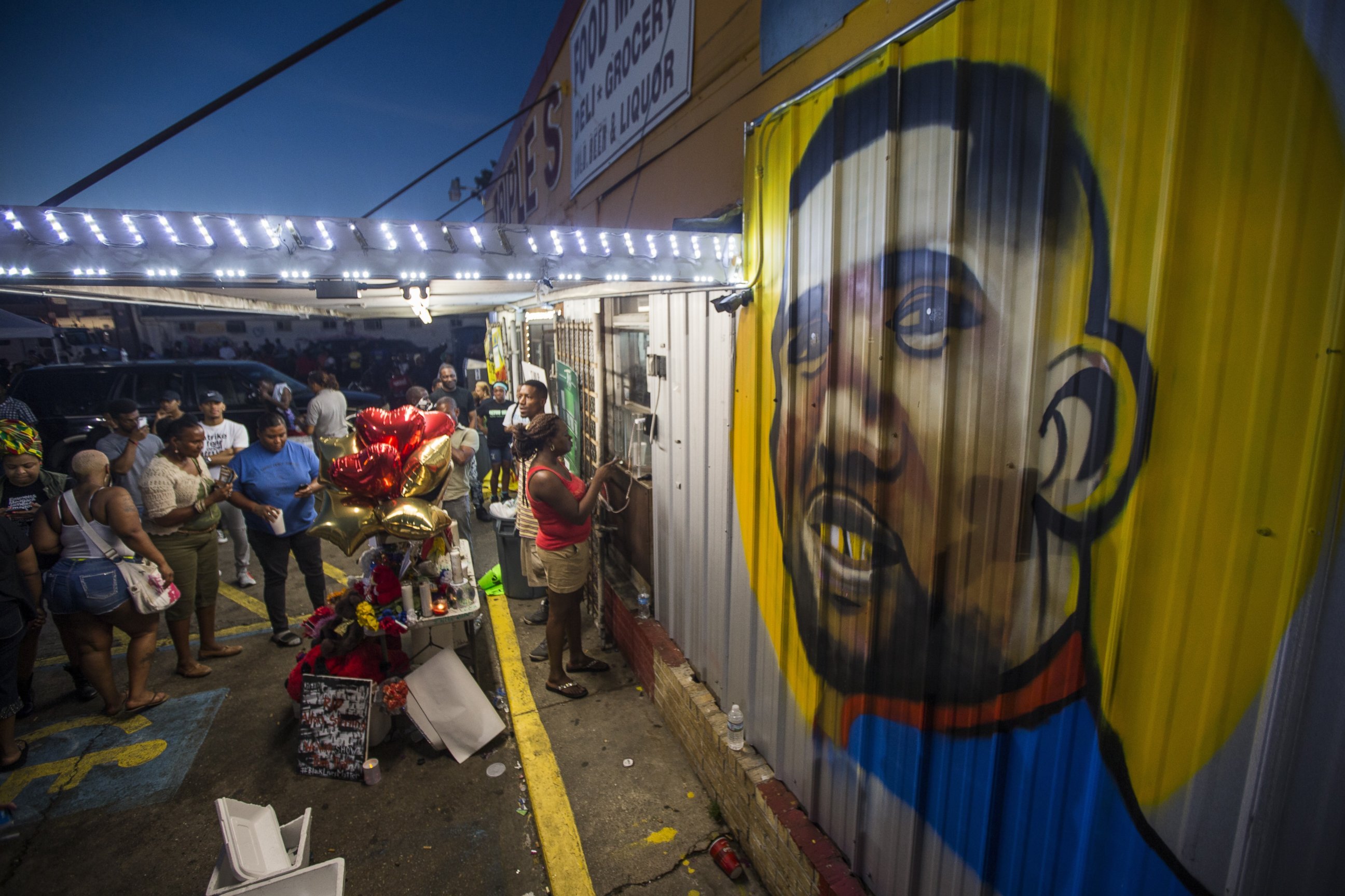 PHOTO: Protesters gather in front of a mural painted on the wall of the convenience store where Alton Sterling was shot and killed, July 6, 2016 in Baton Rouge, Louisiana. 