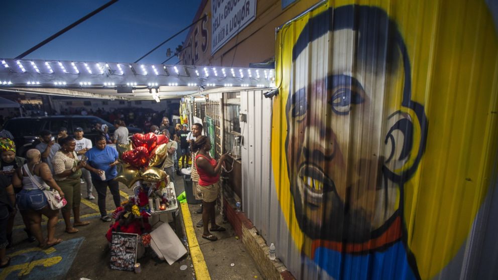 PHOTO: Protesters gather in front of a mural painted on the wall of the convenience store where Alton Sterling was shot and killed, July 6, 2016 in Baton Rouge, Louisiana. 