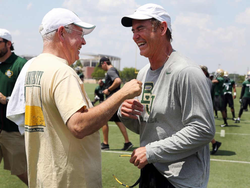 PHOTO: Baylor University President Ken Starr, left, jokes with head football coach Art Briles, right, on the first day of NCAA college football practice in Waco, Texas on Aug. 5, 2014. 