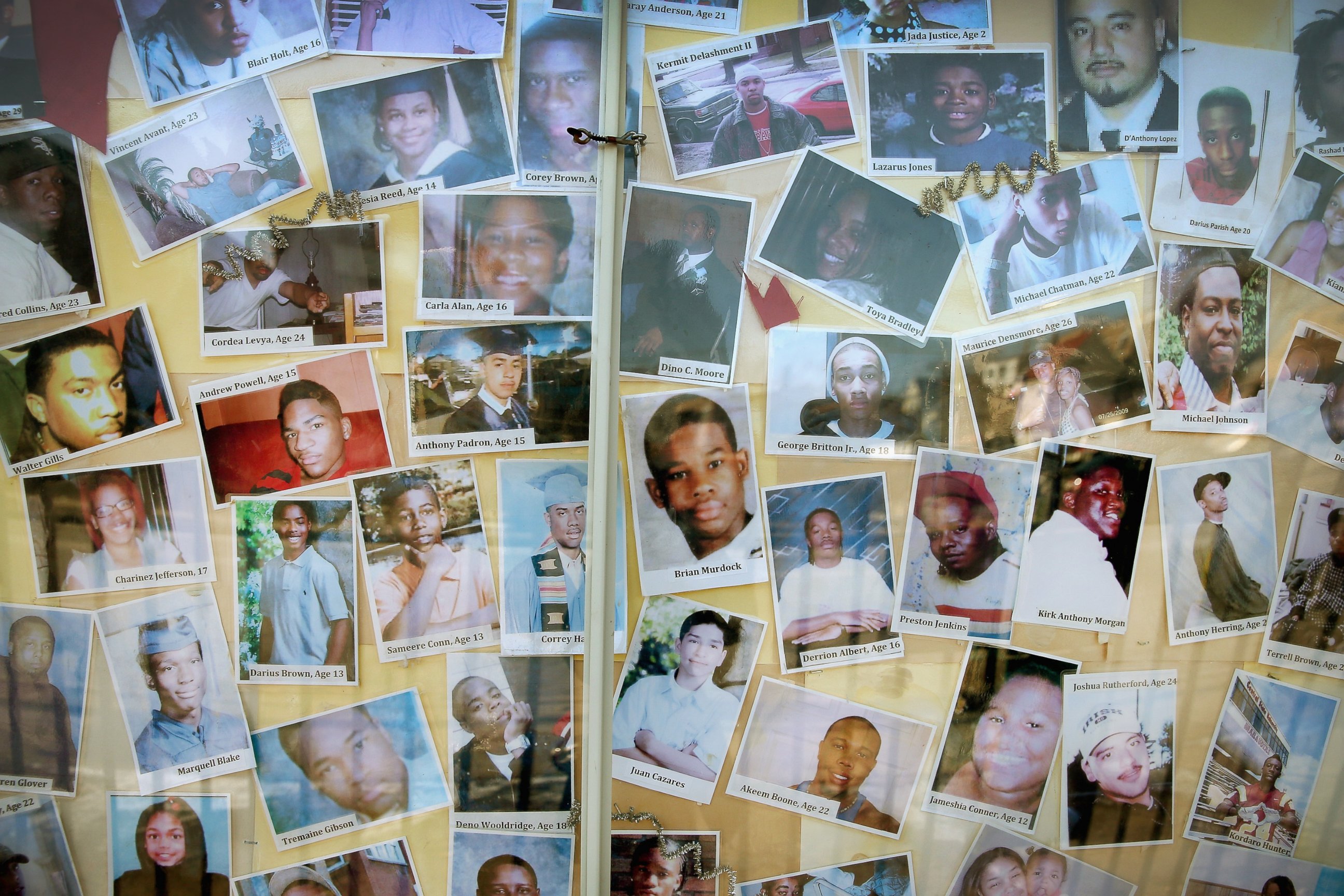 PHOTO: CHICAGO, IL - DECEMBER 23: Pictures of Chicago residents who have died by gunfire are posted next to a Christmas tree outside Saint Sabina Church in the Auburn Gresham neighborhood on the city's Southside on December 23, 2013 in Chicago, Illinois. 