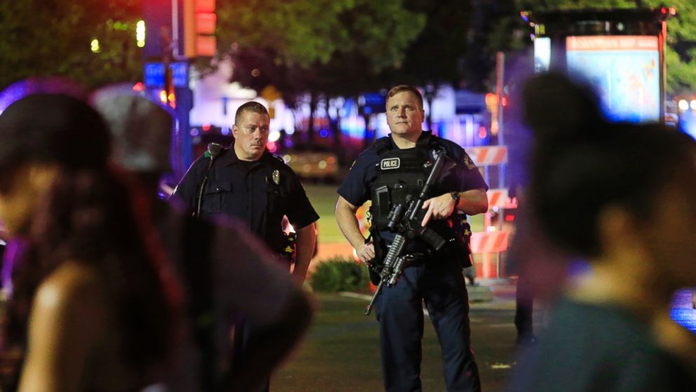 PHOTO: Dallas police and residents stand near the scene where four Dallas police officers were shot and killed on July 7, 2016 in Dallas, Texas.