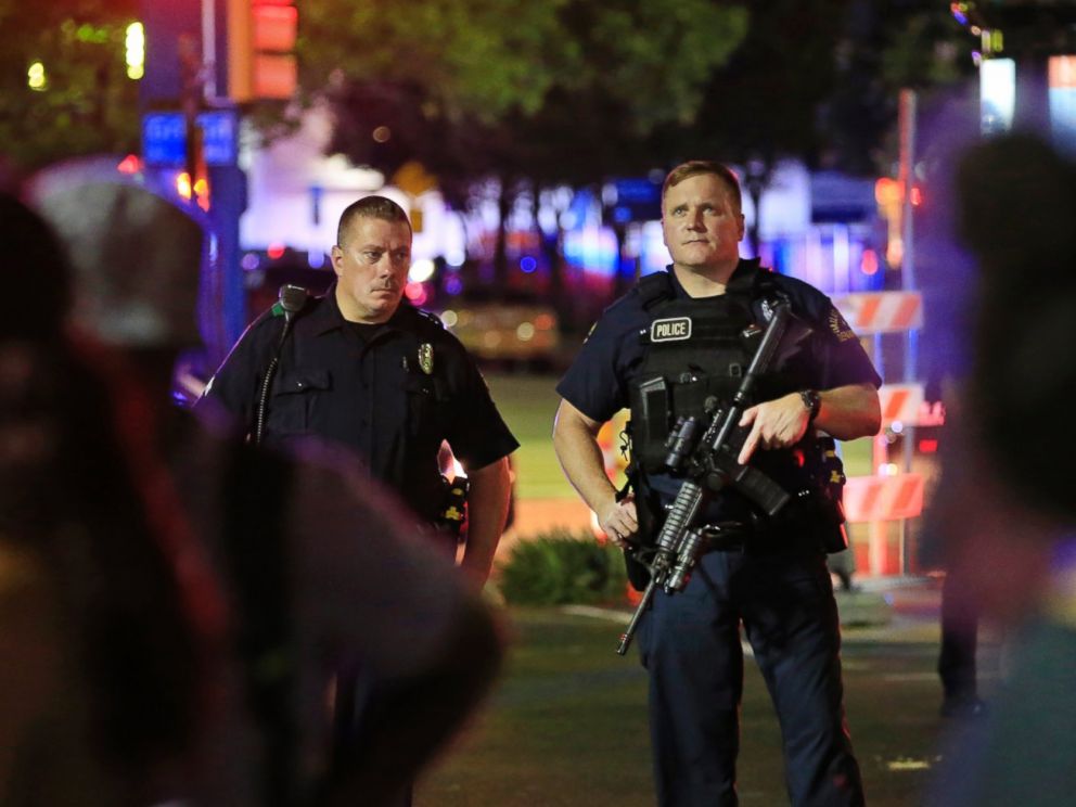 PHOTO: Dallas police and residents stand near the scene where four Dallas police officers were shot and killed on July 7, 2016 in Dallas, Texas.