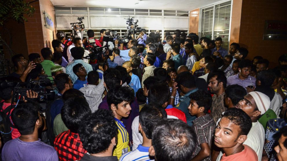 PHOTO: Bangladeshi journalists and onlookers gather in front of an apartment in Dhaka on April 25, 2016. Two people including a leading gay rights activist were hacked to death at an apartment in the Bangladesh capital, police said.