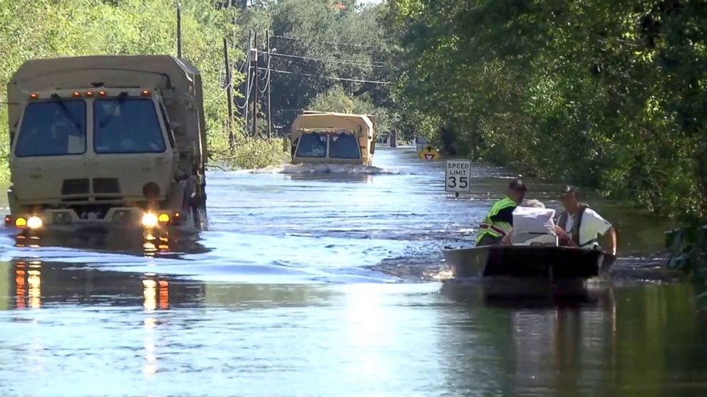 PHOTO: Members of the South Carolina National Guards 1053rd Transportation Company driving LMTVs through deep water, as well as local rescue personnel in boats carrying dozens of evacuees from the flooded town of Nichols, South Carolina, on Oct. 10, 2016.