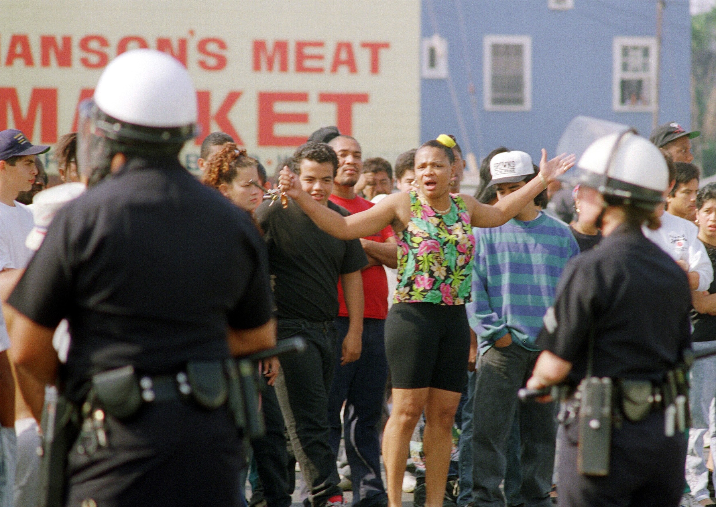 PHOTO: A woman yells at Los Angeles police officers who stand guard outside a shopping center, April 30, 1992, in Los Angeles. 