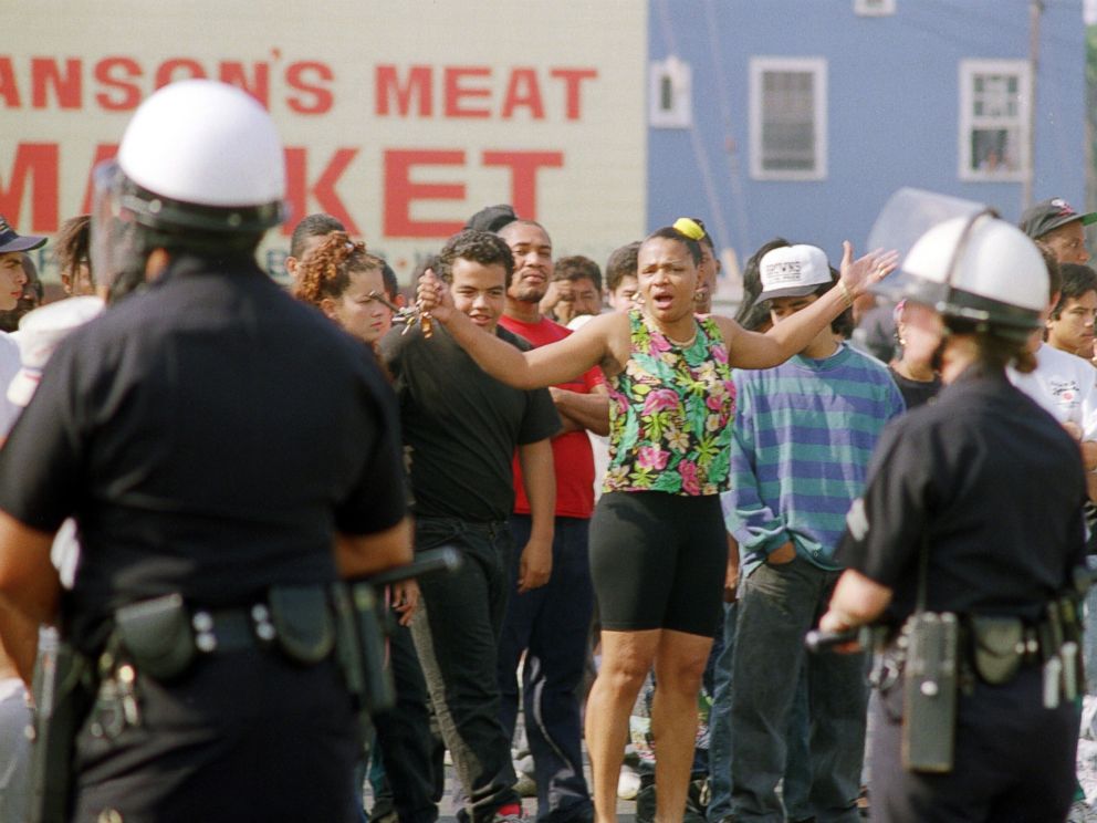 PHOTO: A woman yells at Los Angeles police officers who stand guard outside a shopping center, April 30, 1992, in Los Angeles.
