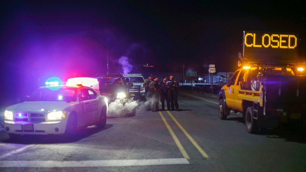 Law enforcement personnel monitor an intersection of closed Highway 395 in Burns, Oregon, Jan. 26, 2016.