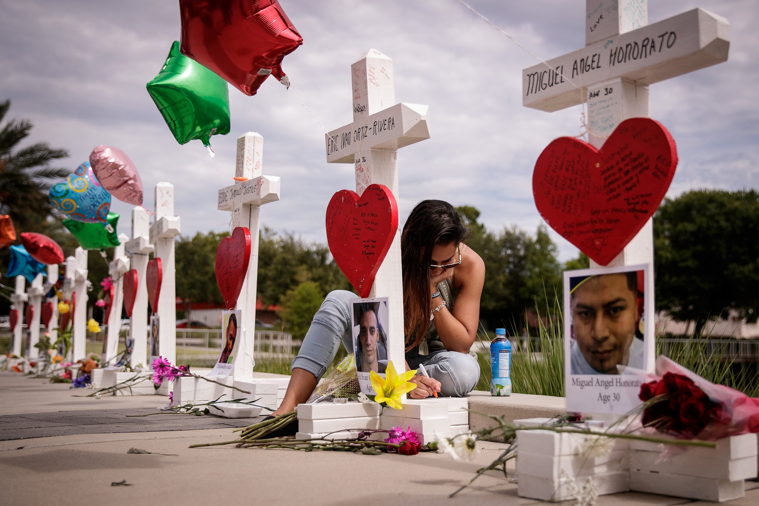 PHOTO:A woman writes a note on a cross for Eric Ivan Ortiz-Rivera at a memorial with wooden crosses for each of the 49 victims of the Pulse Nightclub, next to the Orlando Regional Medical Center, June 17, 2016 in Orlando, Fla. 