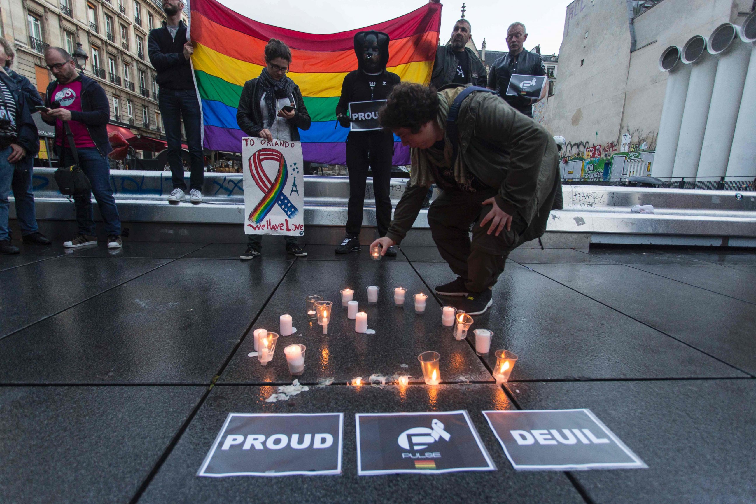 PHOTO: People and members of the gay community hold the peace rainbow flag gather for a vigil near the Beaubourg art center in downtown Paris, June 12, 2016.
