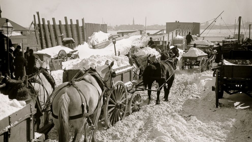 Carts haul snow and ice, cleared from city streets, to the river for dumping in the East River in New York, possibly during the Blizzard of 1888.