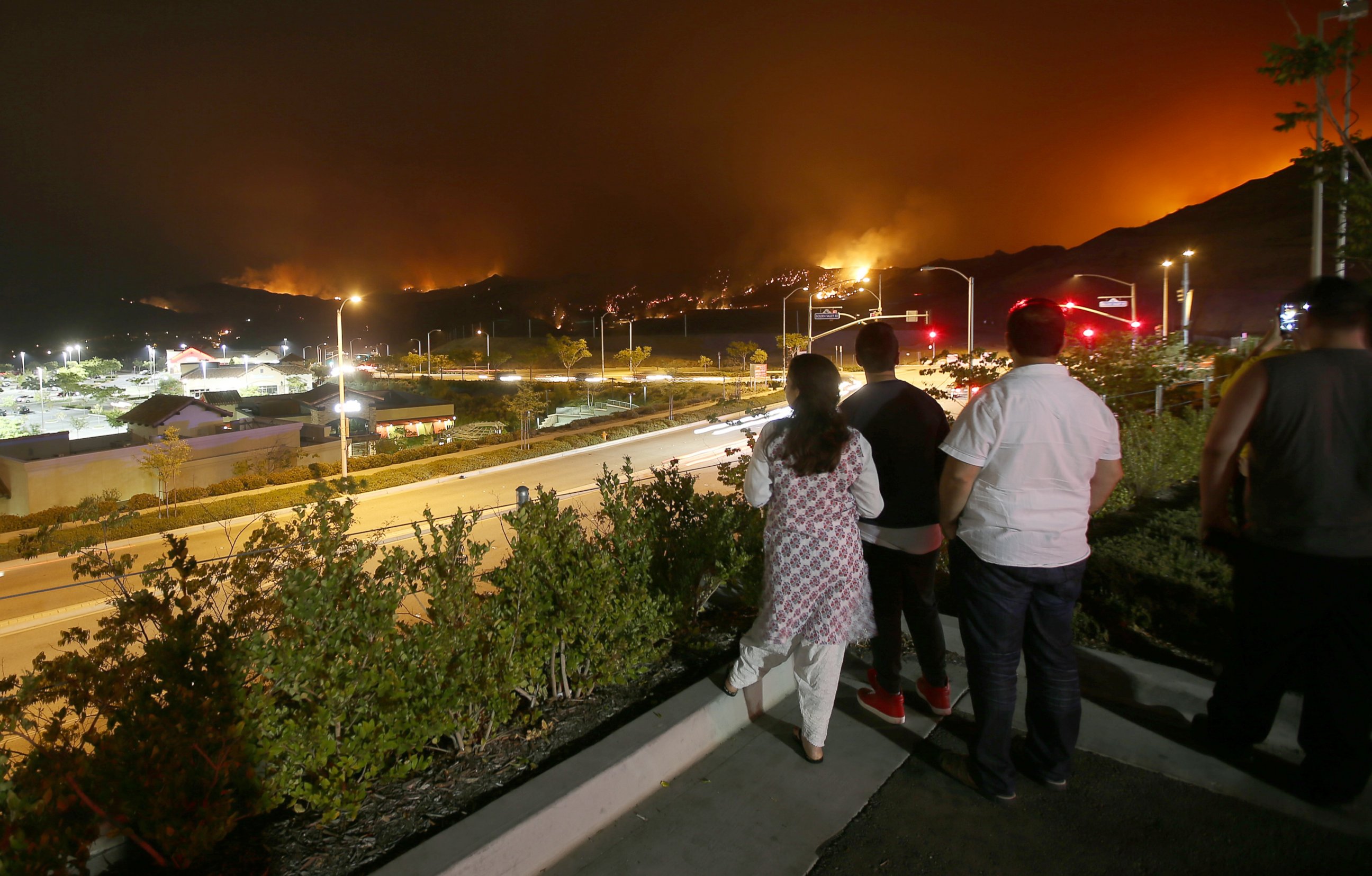 PHOTO: Onlookers gather at the parking lot of a shopping mall along Golden Valley Road in Santa Clarita to watch the Sand fire burn in the hills above the city on July 24, 2016.