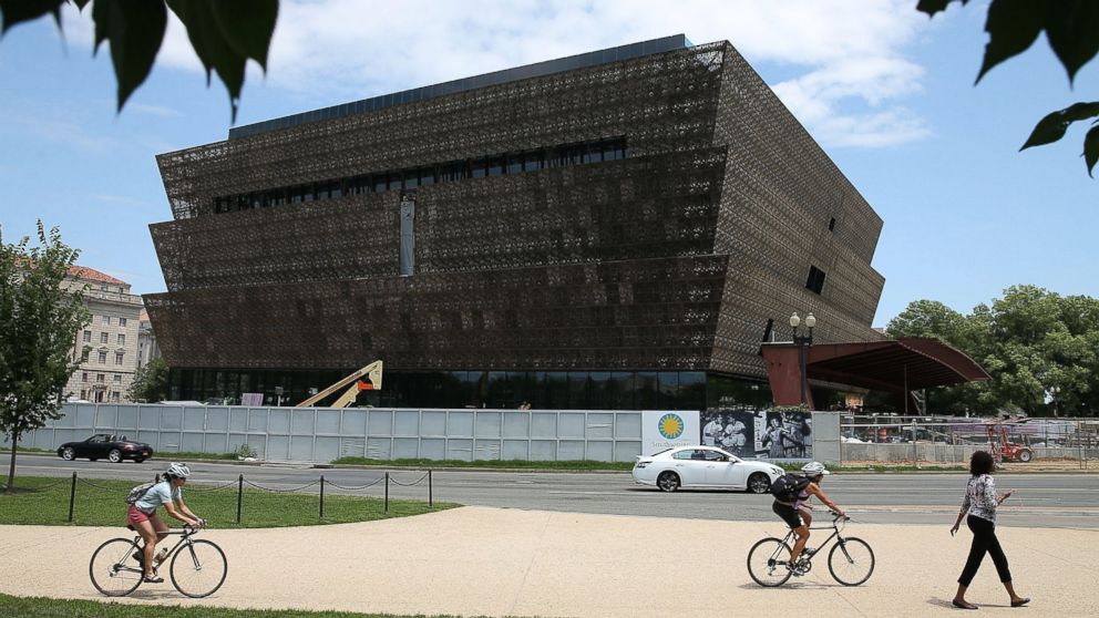 Tourist's walk past the Smithsonian Museum of African American History and Culture that is currently under construction, July 16, 2015 in Washington. 