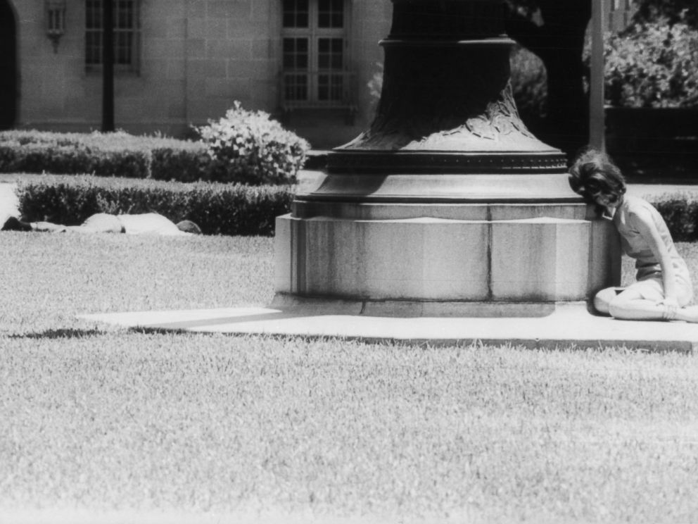 PHOTO: A woman cowers in fear behind a statue while a man lies wounded a few feet away, victim of sniper Charles Whitman, Aug. 1, 1966, in Austin, Texas.