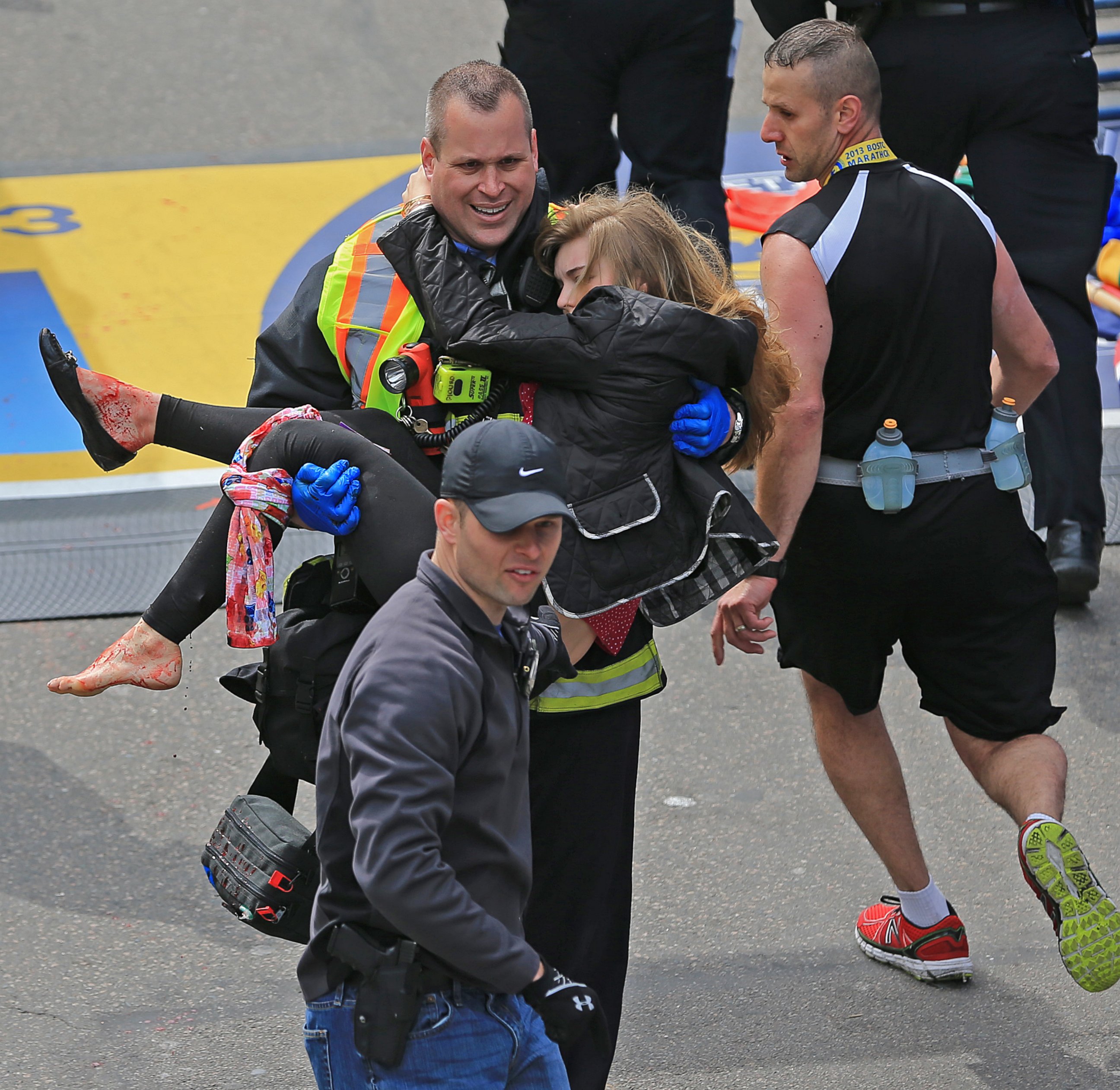 PHOTO: Victim Victoria McGrath is helped to a stretcher by emergency personnel after two explosions went off near the finish line of the 117th Boston Marathon on April 15, 2013. 