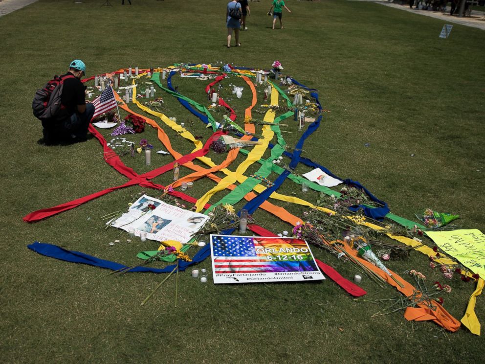 PHOTO: A gay pride ribbon is displayed on the lawn of the Dr. Phillips Performing Arts Center, near a makeshift memorial for the victims of the Pulse Nightclub shooting June 14, 2016 in Orlando, Florida.