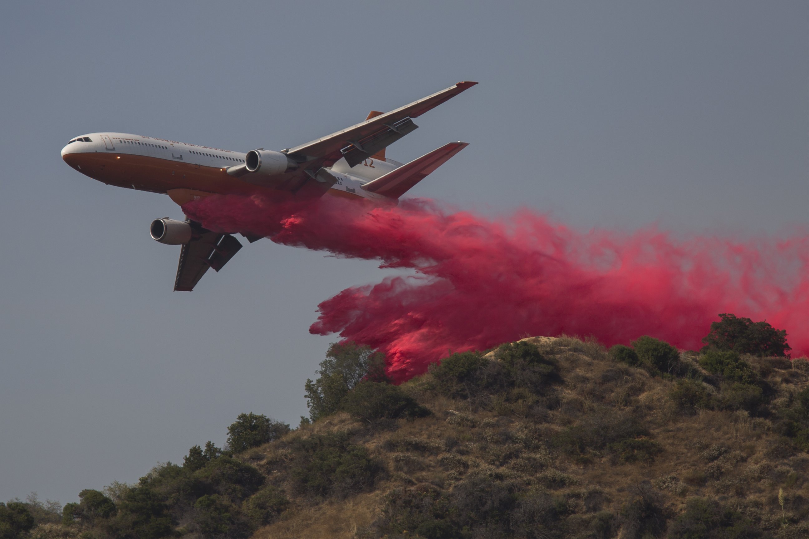 PHOTO: A converted DC-10 Air Tanker drops fire retardant along a ridge to protect communities that border the wilderness at the San Gabriel Complex Fire in the Angeles National Forest on June 21, 2016 near Monrovia, Calif.