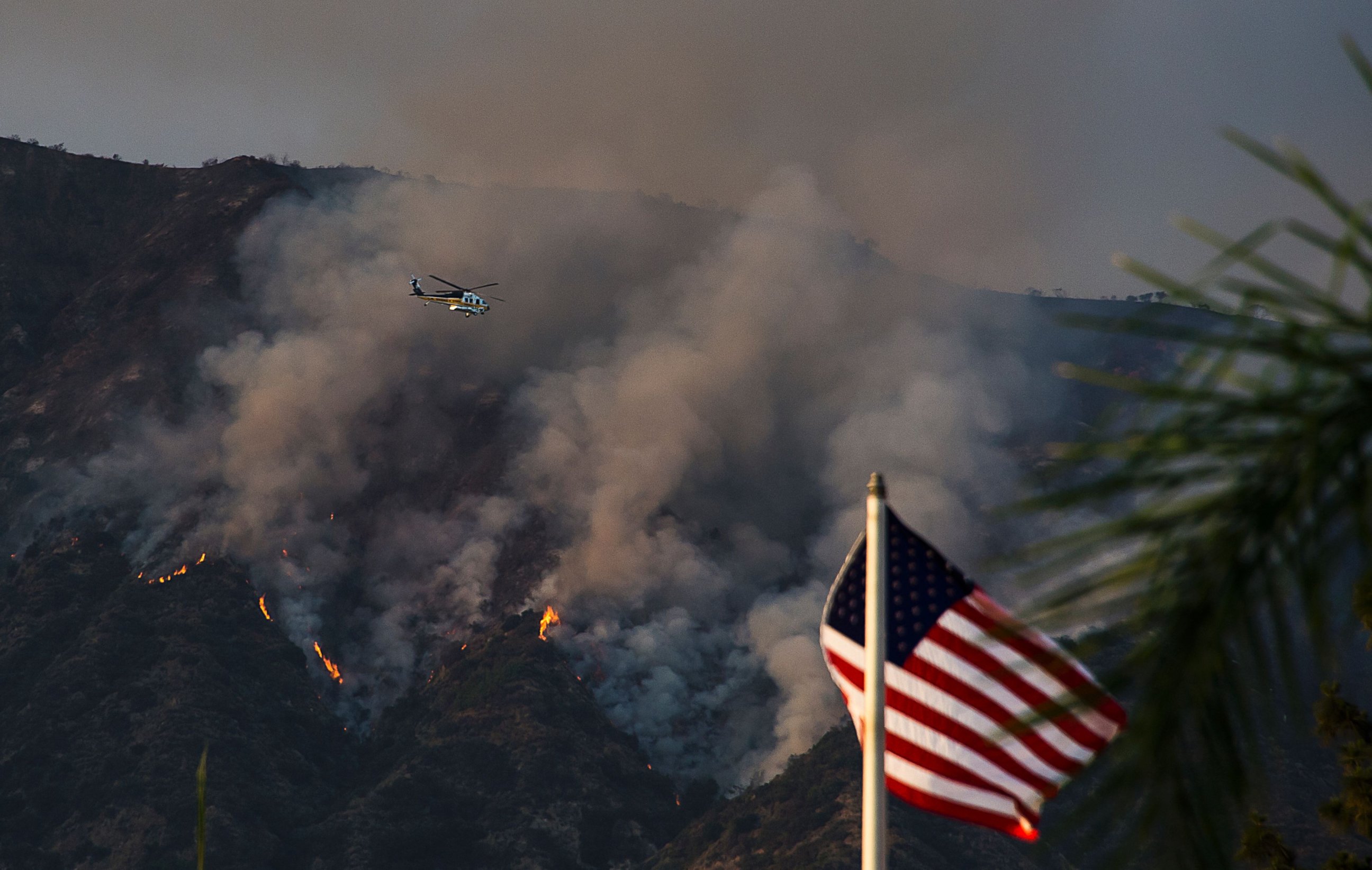 PHOTO: A Los Angeles County Fire helicopter flies over smoke and flames at the San Gabriel Complex Fire in the Angeles National Forest, June 21, 2016 near Duarte, Calif.