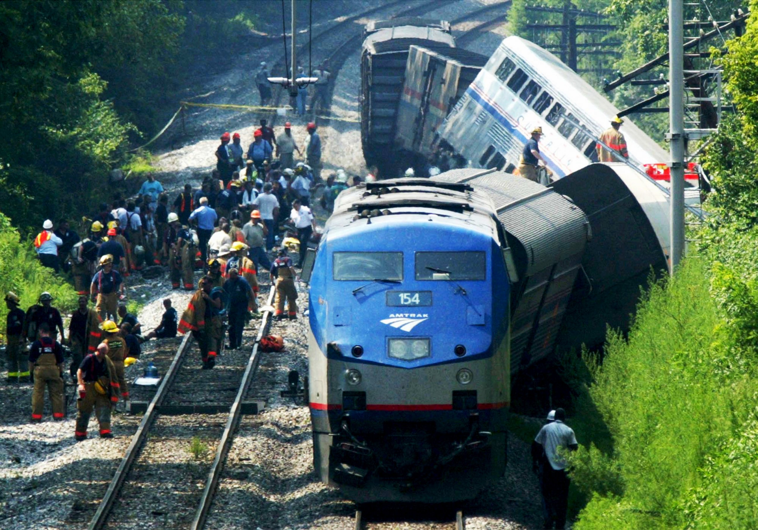 PHOTO: Rescue workers stand next to a derailed Amtrak passenger train which was on route from Chicago to Washington, July 29, 2002.