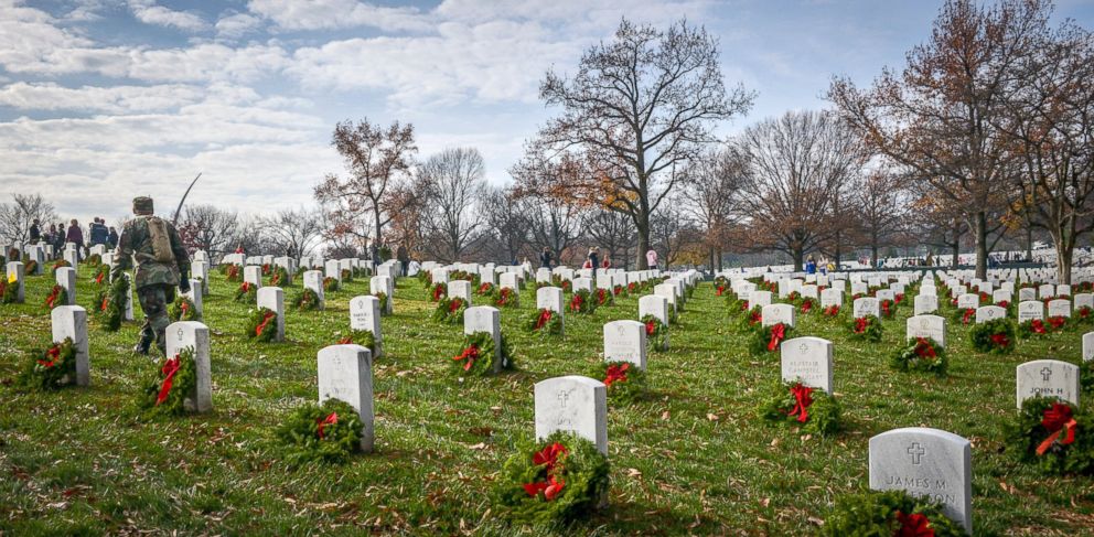 PHOTO: Volunteers carry wreaths in search of unadorned gravesite during as they participate in Wreath Across America, to lay wreaths on each grave in Arlington National Cemetery, Dec. 12, 2015, in Arlington.