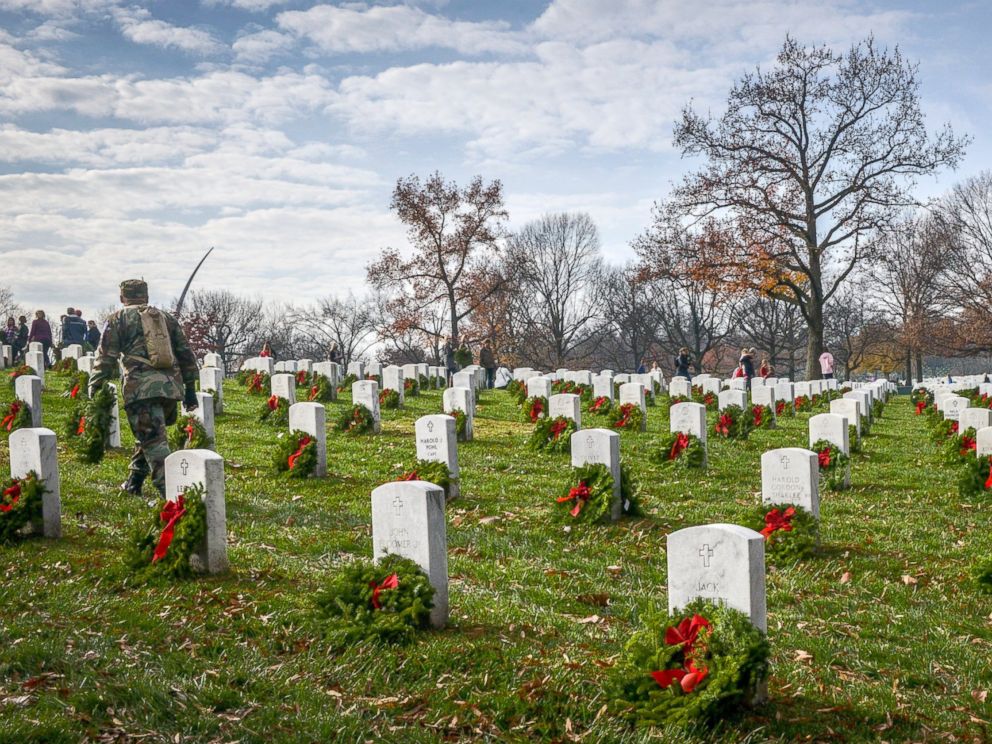PHOTO: Volunteers carry wreaths in search of unadorned gravesite during as they participate in Wreath Across America, to lay wreaths on each grave in Arlington National Cemetery, Dec. 12, 2015, in Arlington.