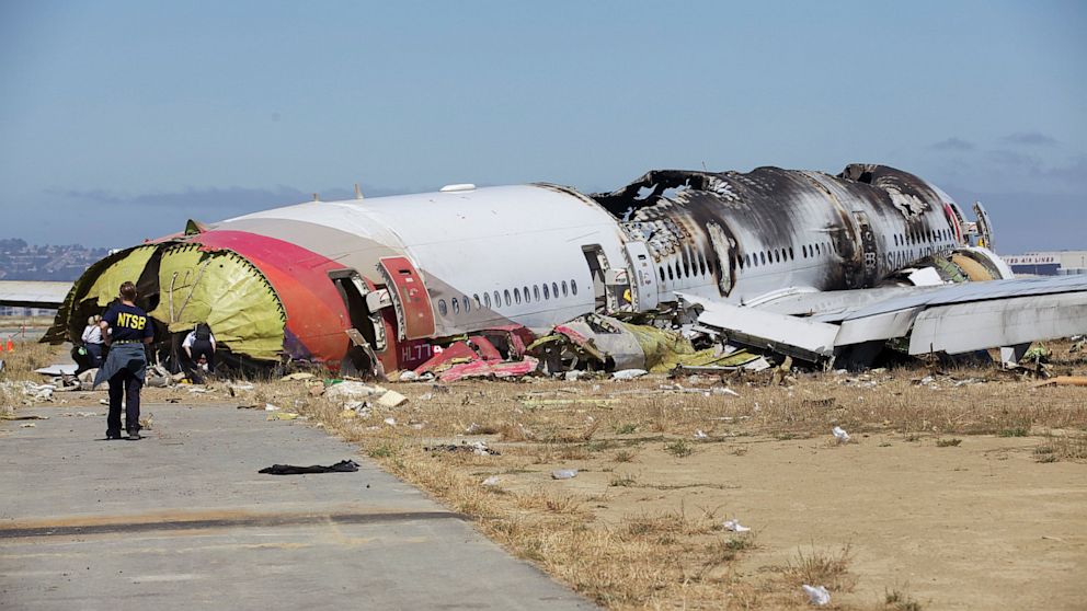 National Transportation Safety Board investigators examine the rear end of Asiana Airlines flight 214 after the crash July 7, 2013, in San Francisco.